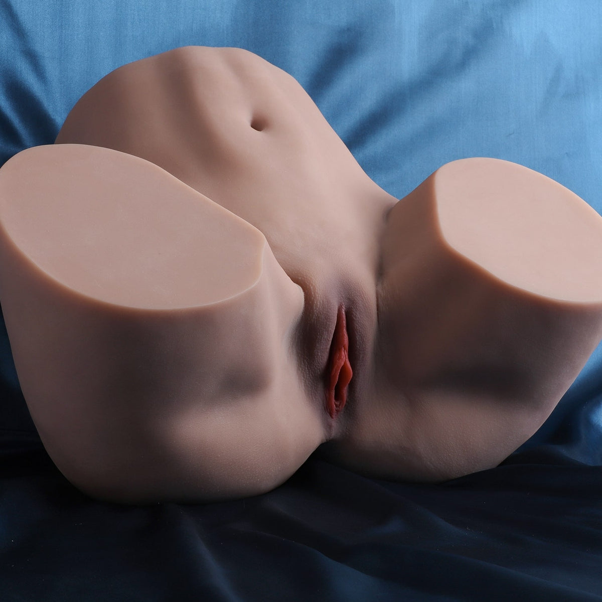 Loes, vagin artificiel et fesses sur fond satiné, vue de côté avec la vulve
