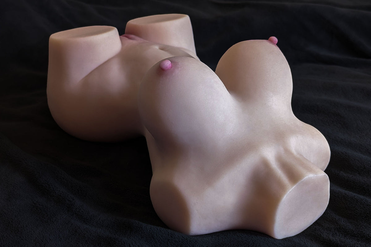 Poupée sexuelle - Torse Sara allongée sur un fond sombre, vue de côté avec les seins
